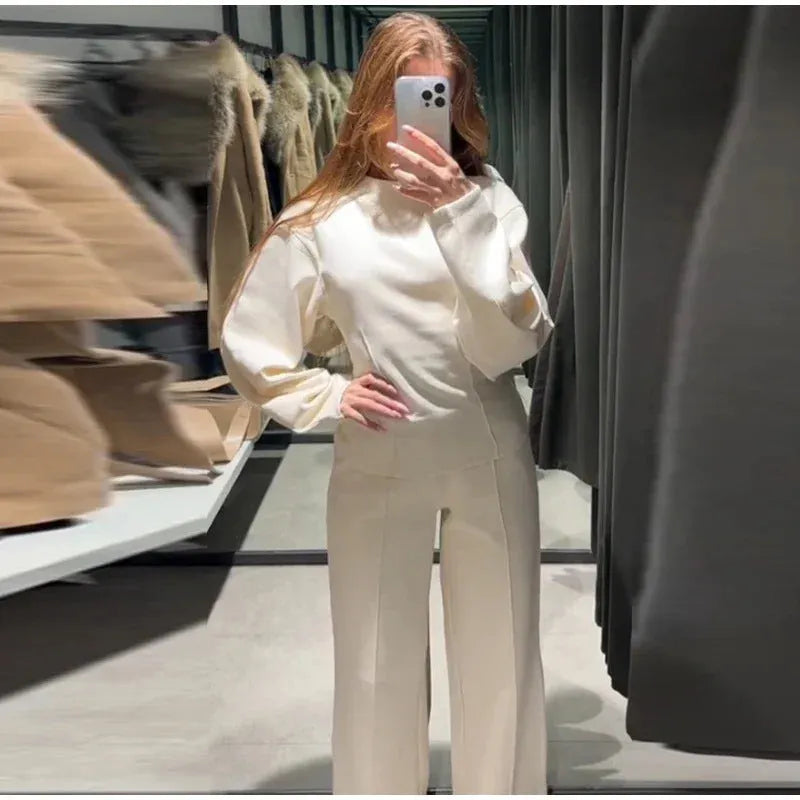Women's black polar fleece long sleeve pleated top and wide leg trousers co-ord set on a hanger.