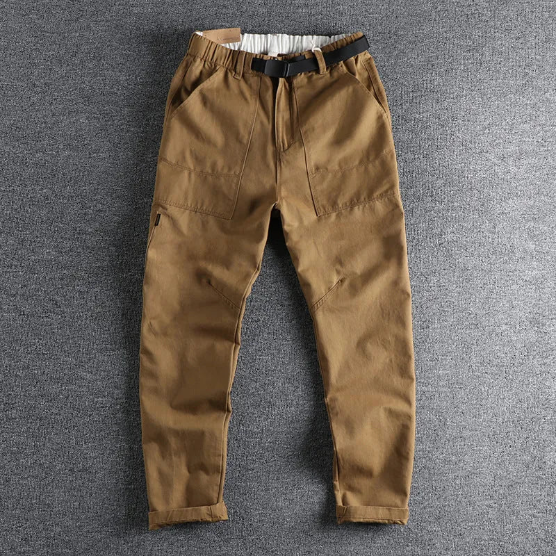 Men's khaki cotton work trousers with N I buckle belt showing three-dimensional cutting and mid waist design