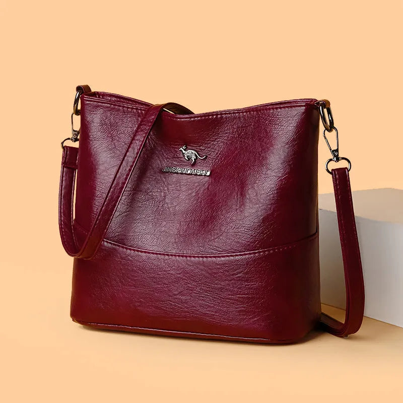 Women's soft leather bucket shoulder bag in black, shown with minimalist design and sewing line detail.