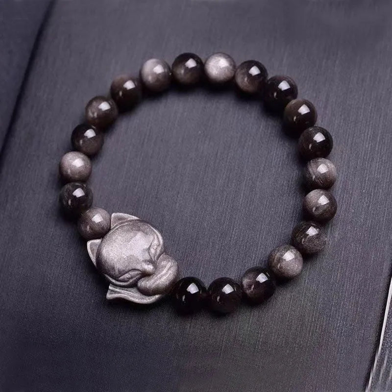 Adjustable obsidian bracelet with a single polished 8mm bead carved with a fox design.