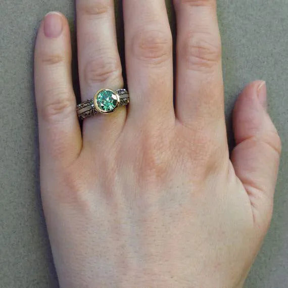 Gold and silver vintage flower-shaped ring with a central green gemstone, shown in a size selection.