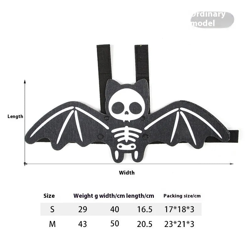 Black cat wearing an orange felt batwing Halloween costume with bell attachment.