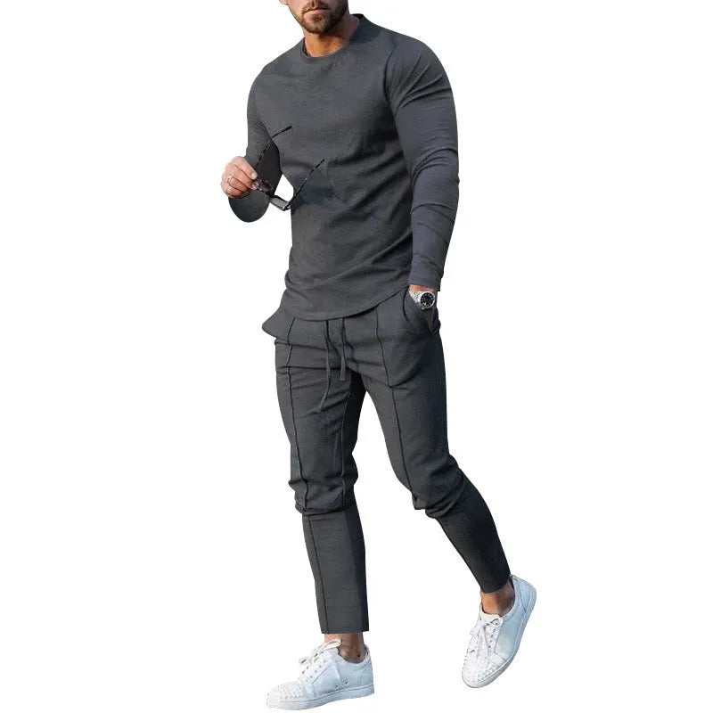 Man wearing a light grey round-neck long-sleeve t-shirt and matching trousers from a two-piece polyester suit set.