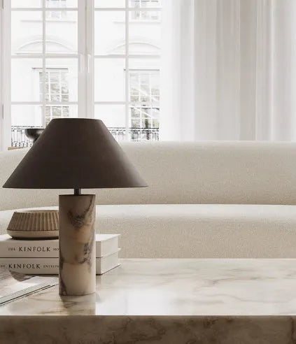 Black modern table lamp with a marble base on a wooden desk.