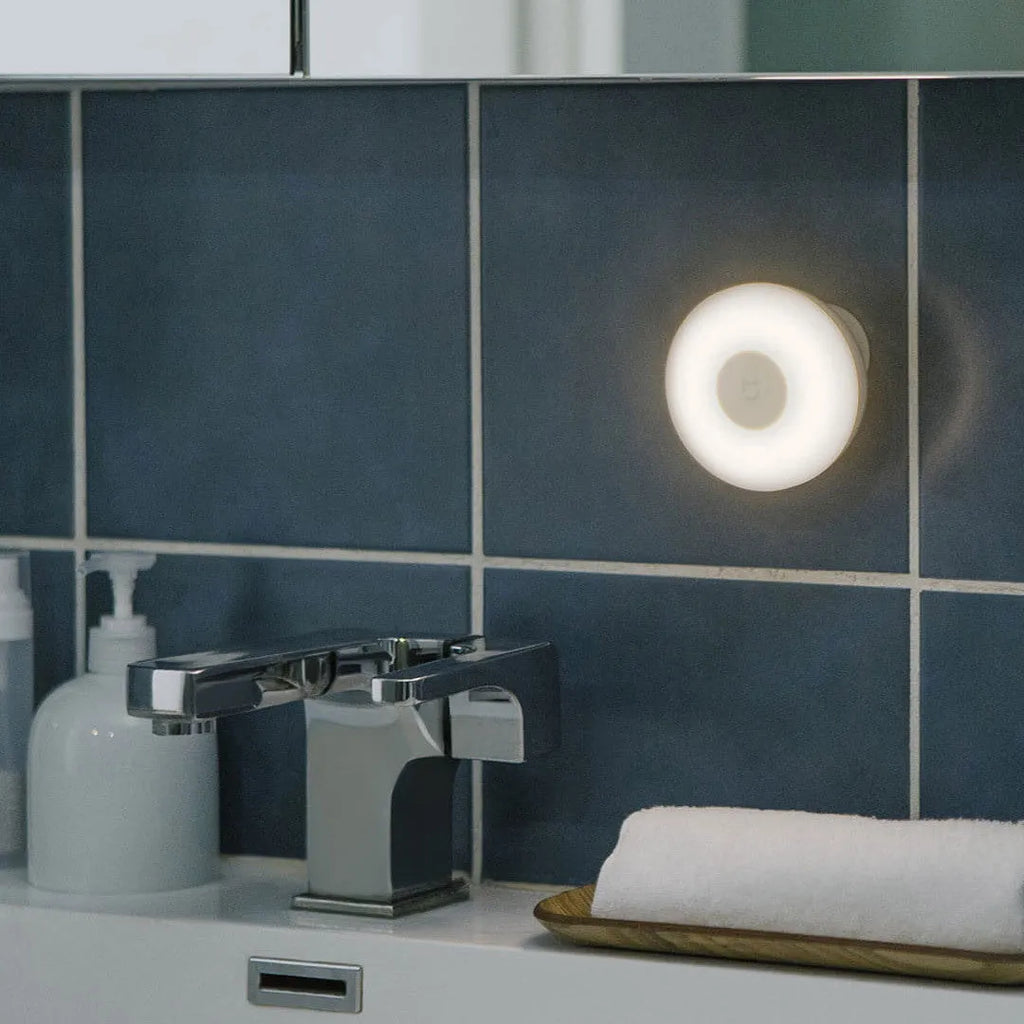 White Mijia Bluetooth bedside night light with human body induction on a wooden table.