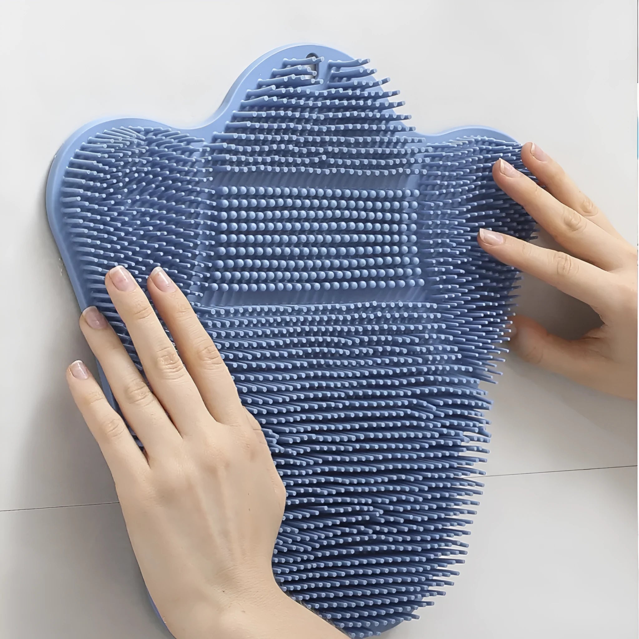 Blue silicone bath scrubber mat with bristles, shown next to grey and pink colour options.