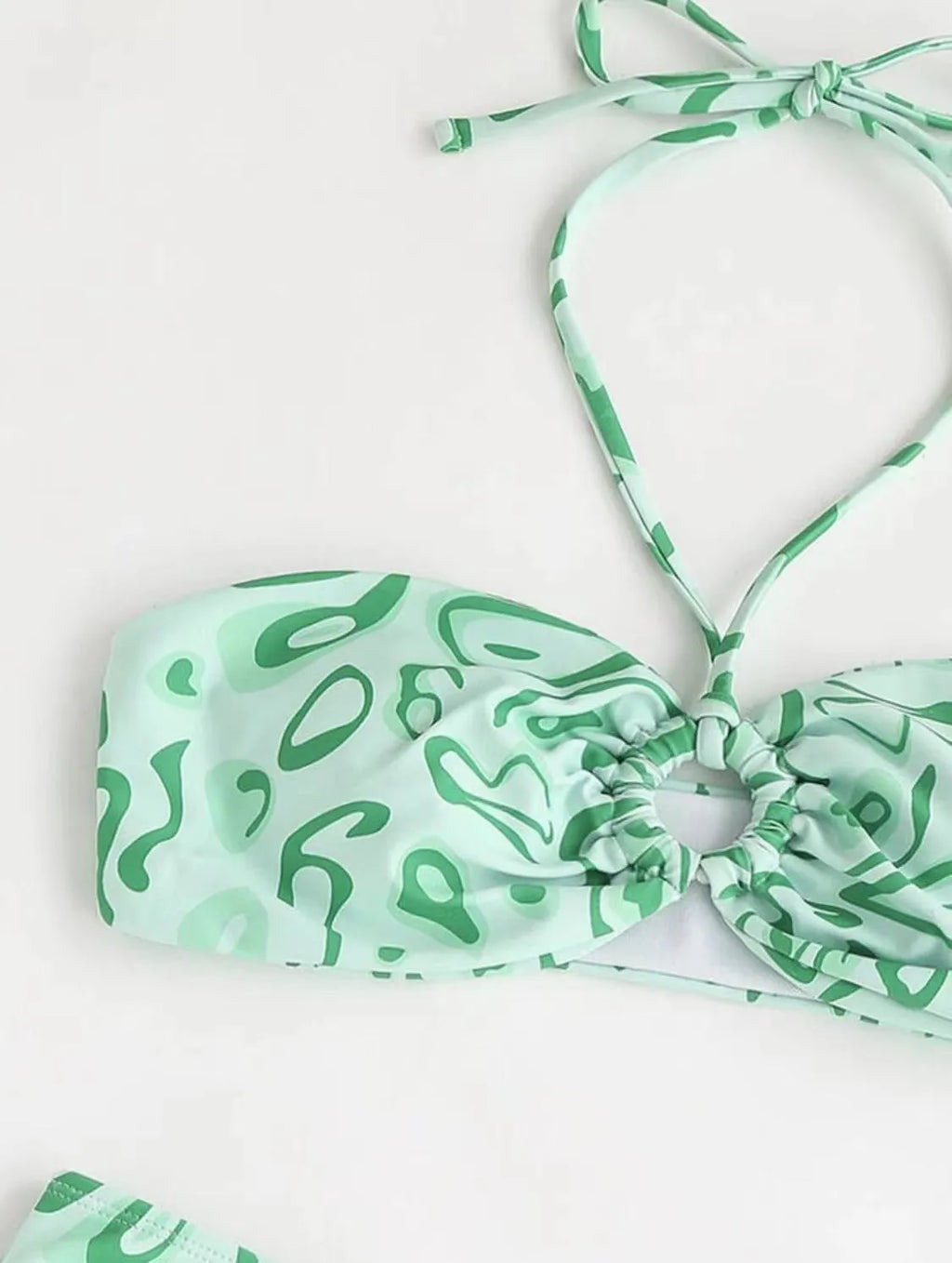 Green floral bandeau bikini swimsuit with split design on a mannequin