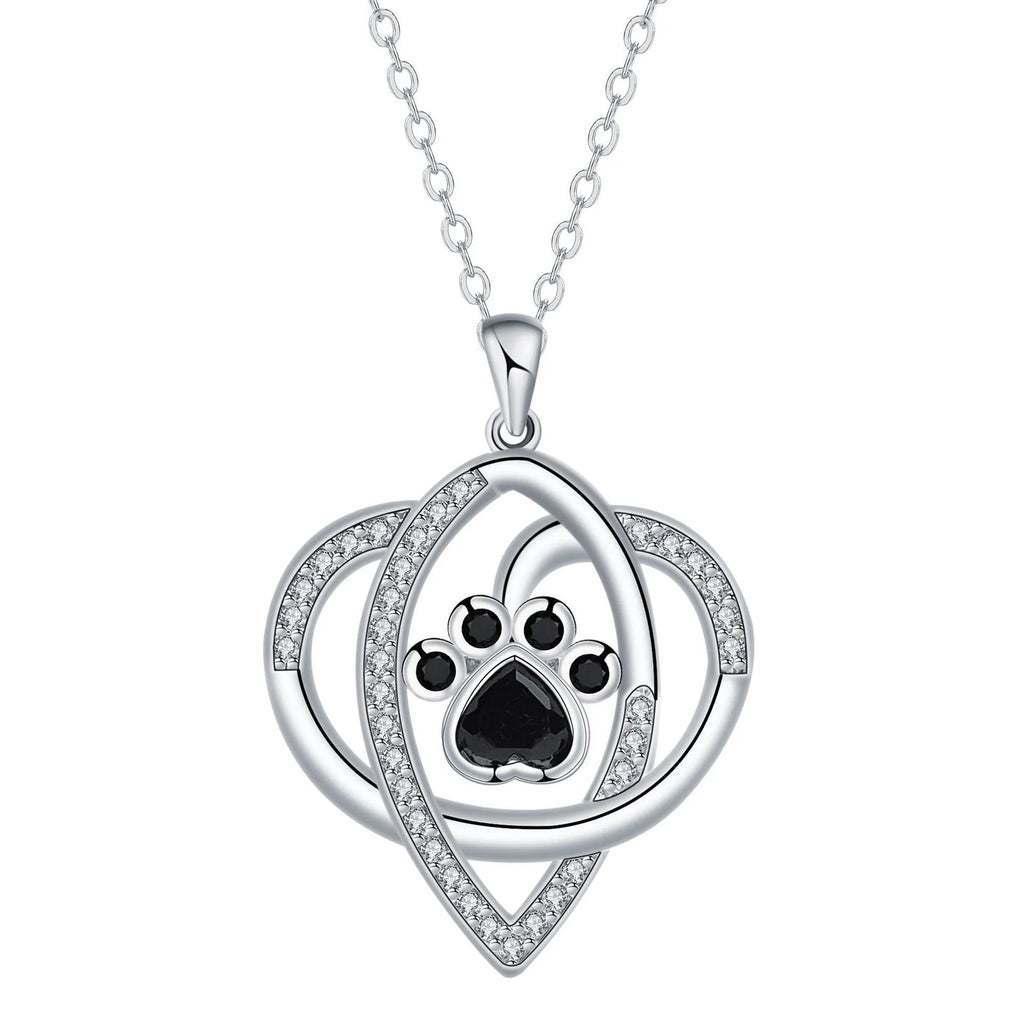 Close-up of a copper necklace pendant showing detailed cat and dog paw prints on a cross chain.