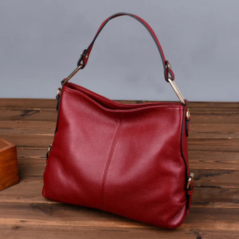 Genuine leather women's crossbody bag in square vertical design, showing internal zipped phone and document pockets.
