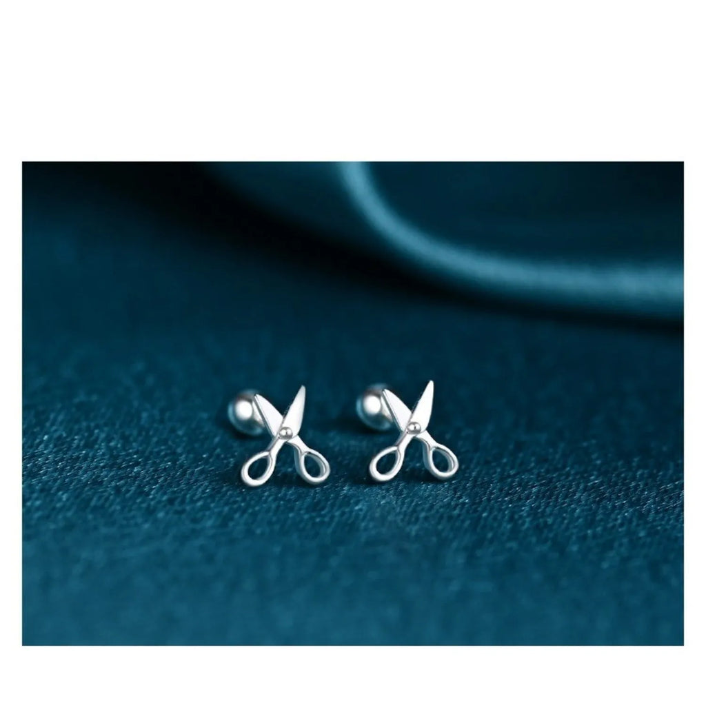 A pair of pure silver screw-style earrings for cartilage piercings with mini scissors screw details.