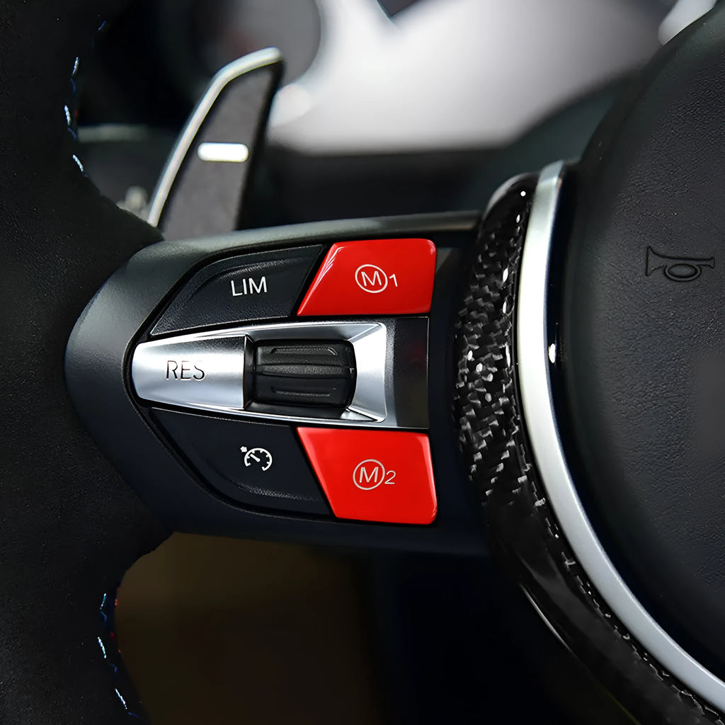 Pair of red and blue BMW M1 M2 steering wheel mode buttons with installation keys on a plain background.