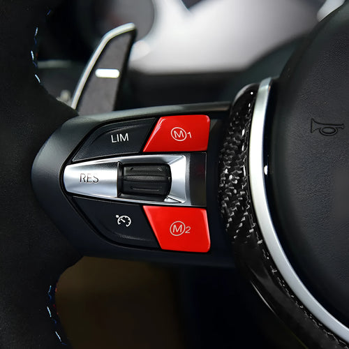 Pair of red and blue BMW M1 M2 steering wheel mode buttons with installation keys on a plain background.