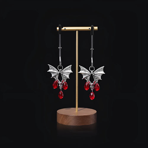 Silver bat-shaped adjustable nipple clamps with ruby decoration on a black background