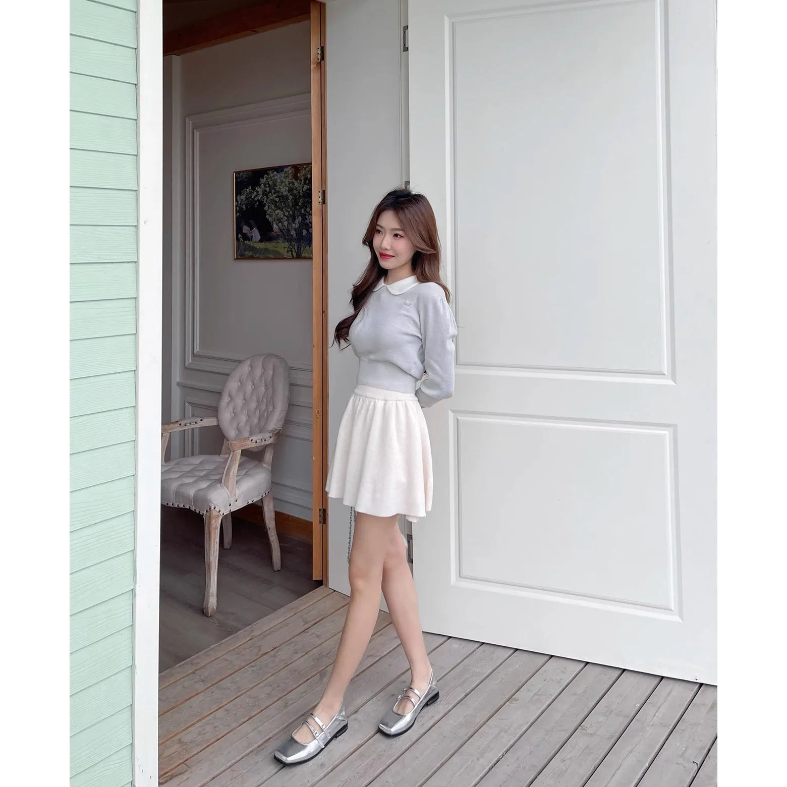 Women's silver sheepskin leather ballet flats with a cross buckle strap and round toe, shown on a plain background.