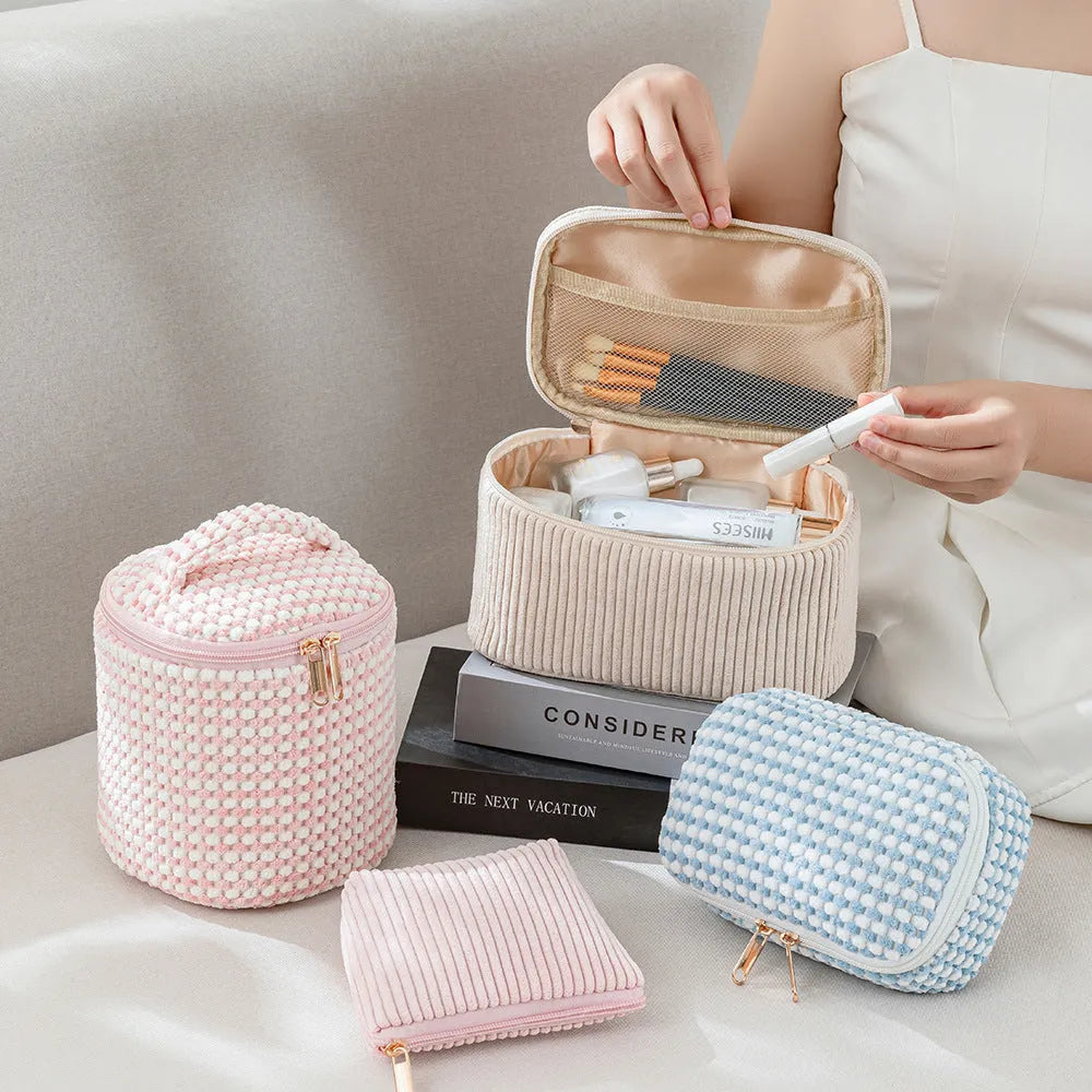 Four cube-style polyester makeup bags in blue with dots, khaki, pink, and pink dots colours arranged together