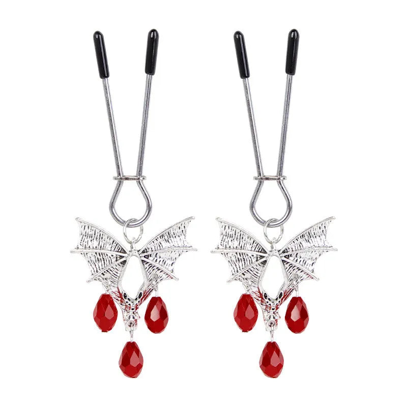 Silver bat-shaped adjustable nipple clamps with ruby decoration on a black background
