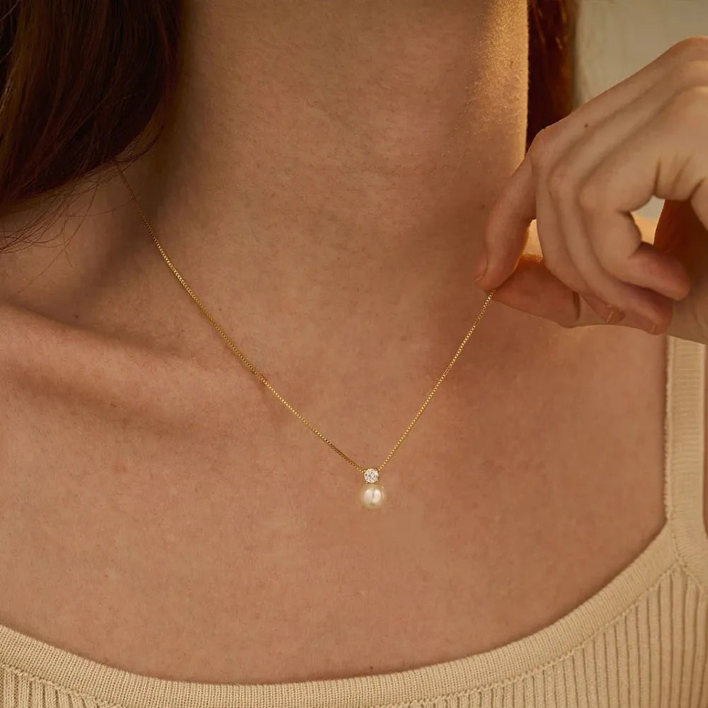Simple stainless steel necklace for women with imitation pearl and zircon pendant in New Chinese style.