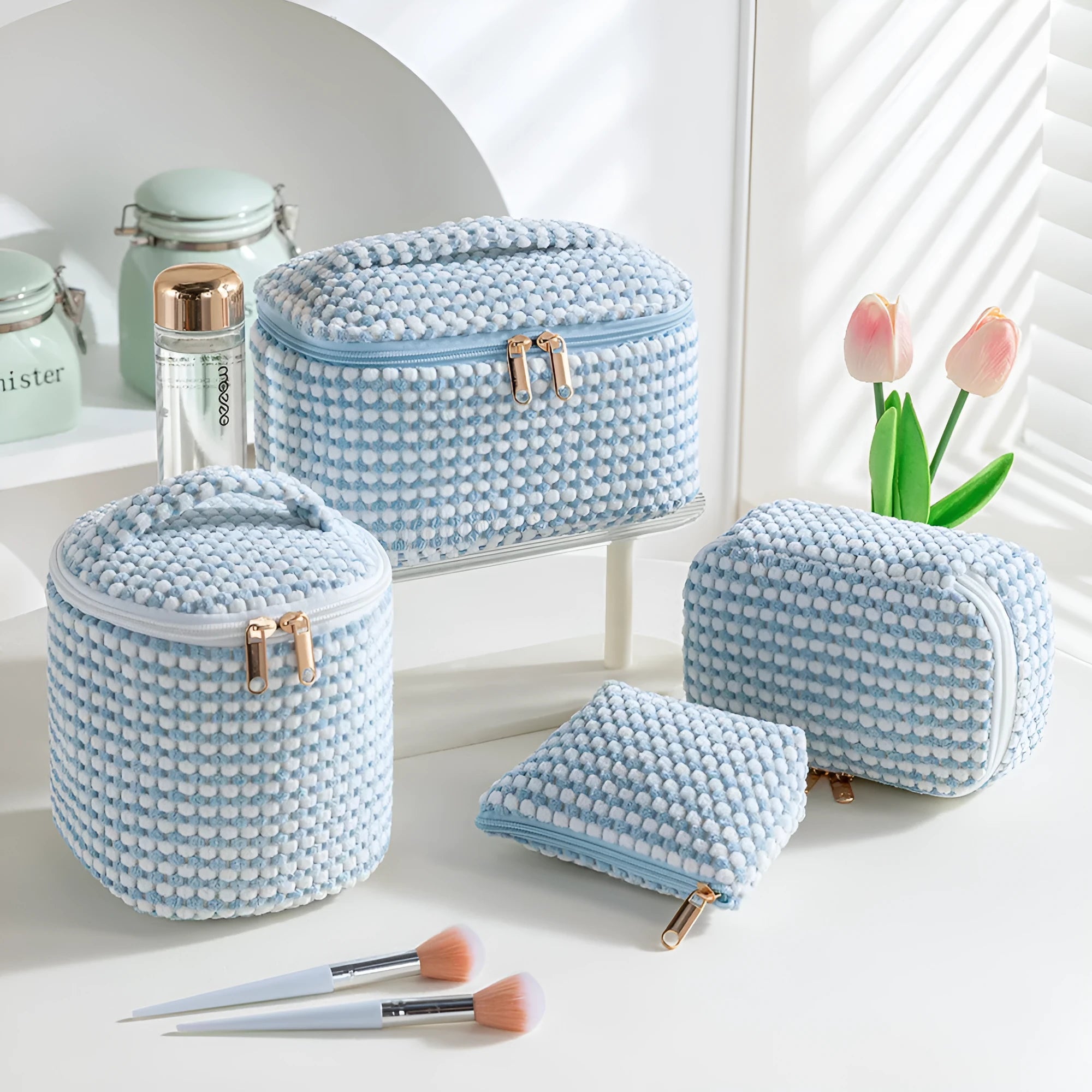 Four cube-style polyester makeup bags in blue with dots, khaki, pink, and pink dots colours arranged together