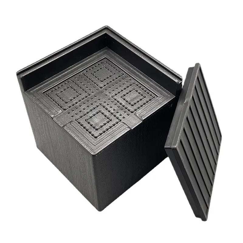Four black plastic circular furniture riser feet on a floor