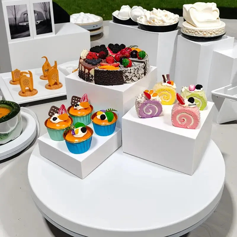 White plastic cube-style dessert display stand with six pieces for cupcakes and cakes.