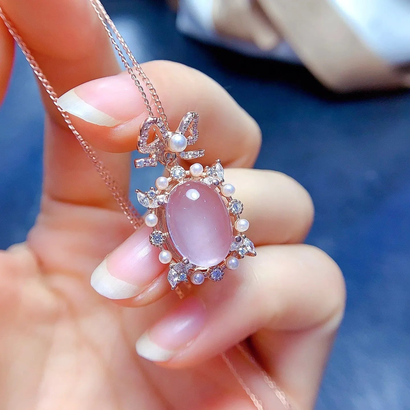 Geometric silver pendant necklace with a pink rose quartz crystal and rose gold plating.