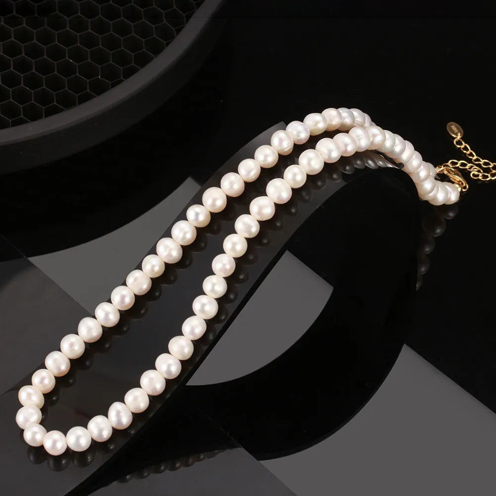 Close-up of a women's adjustable necklace with a round natural freshwater pearl on a silver chain.