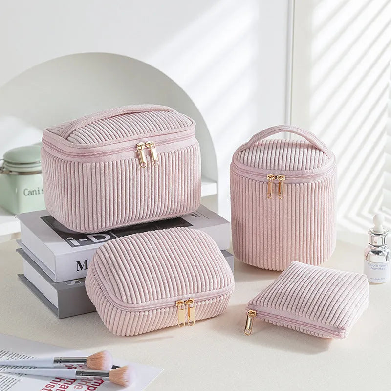 Four cube-style polyester makeup bags in blue with dots, khaki, pink, and pink dots colours arranged together