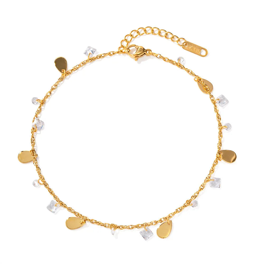 Close-up of a stainless steel geometric anklet with a personalised water drop tassel pendant.