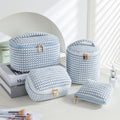 Four cube-style polyester makeup bags in blue with dots, khaki, pink, and pink dots colours arranged together