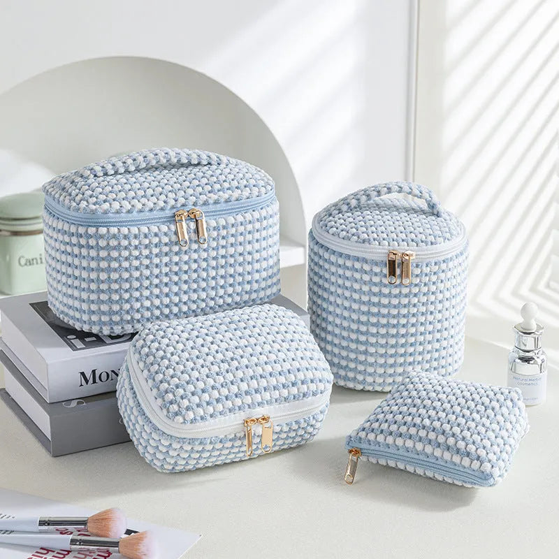 Four cube-style polyester makeup bags in blue with dots, khaki, pink, and pink dots colours arranged together