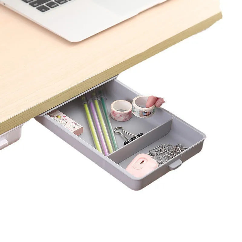 White plastic adhesive under desk storage drawer box with a lid and internal divider grid for organisation.