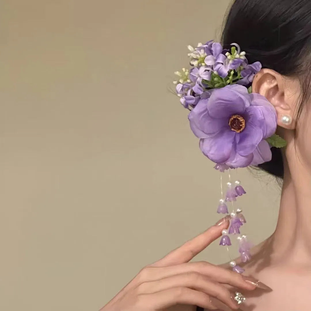 Close-up of a handcrafted hair clip with a colourful flower tassel decoration on a side-clip base.