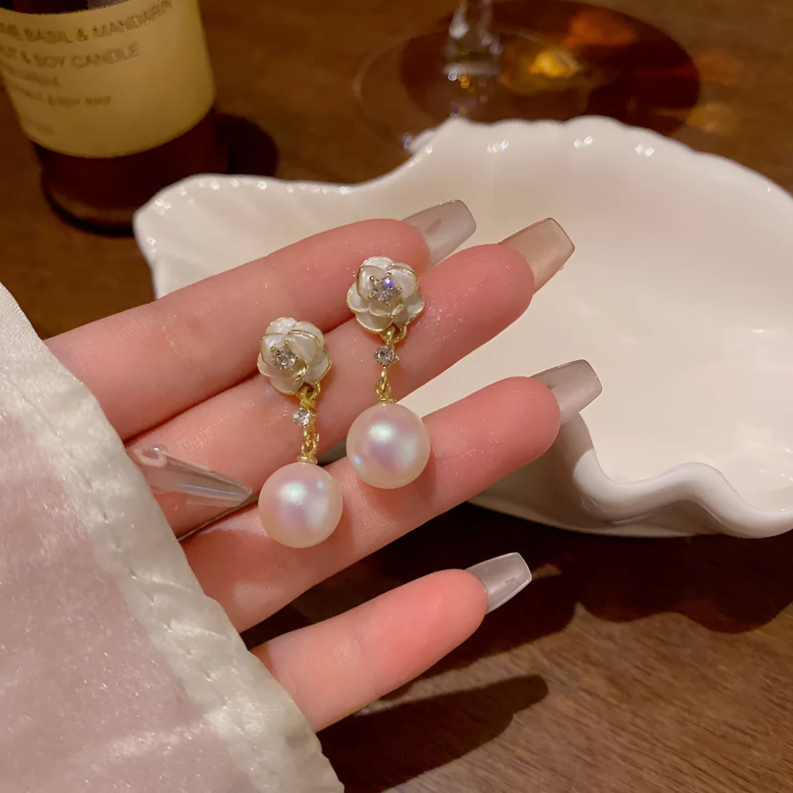 Close-up of camellia flower stud earrings for women showing alloy metal construction and floral detailing