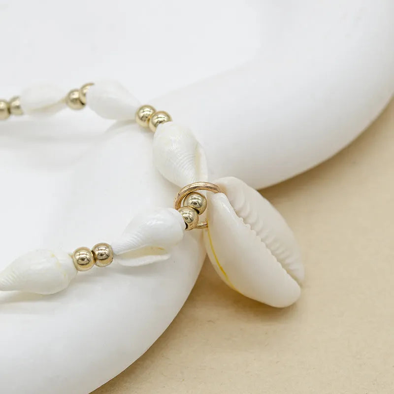 White shell bead necklace with a mother pearl pendant on a silver-toned chain.