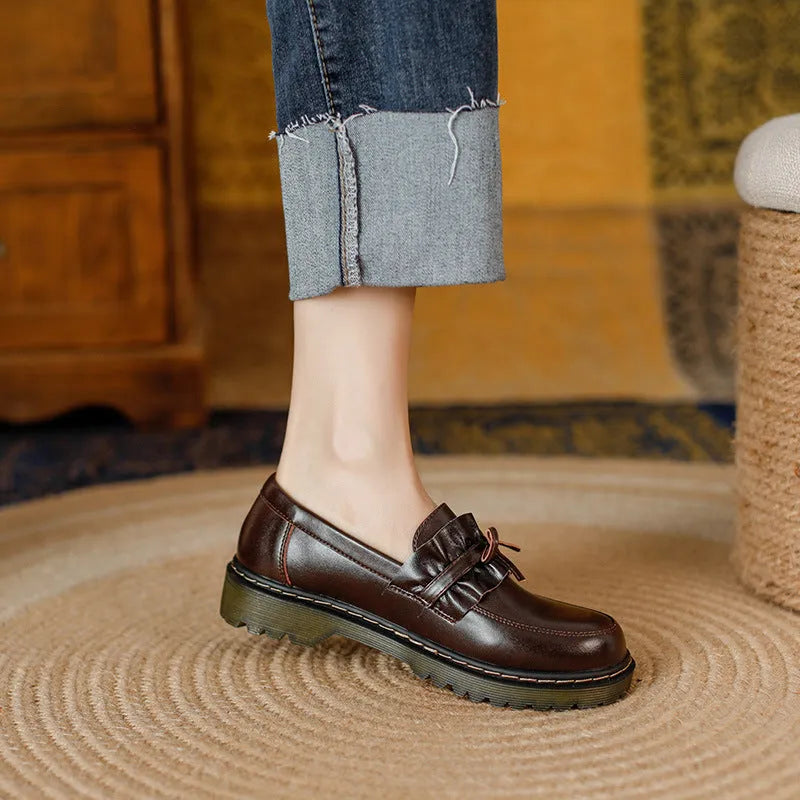 Women's black round-toe leather shoes with a chunky flat heel and lace-up front.