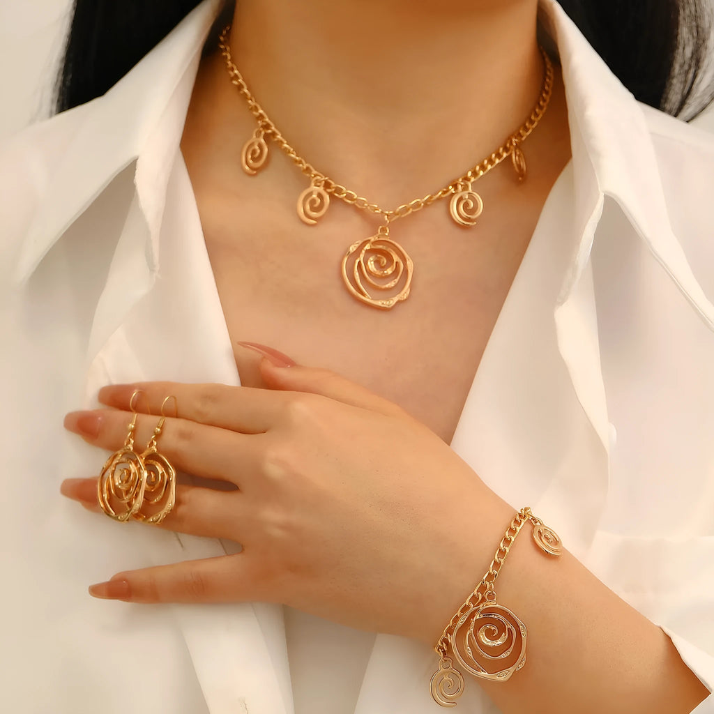 Spiral donut jewellery set showing gold tone necklace, bracelet and earrings with geometric circular design