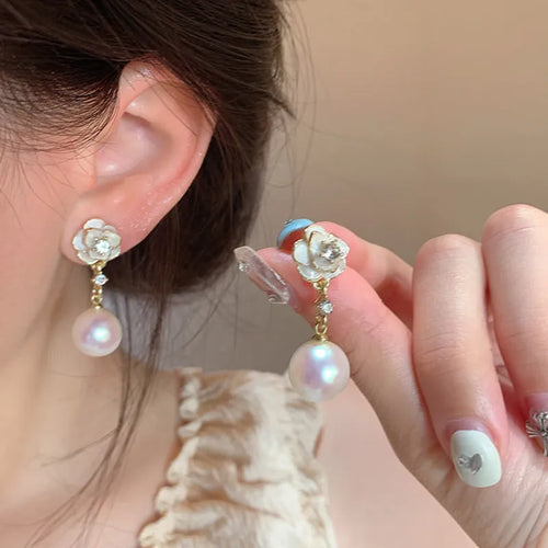 Close-up of camellia flower stud earrings for women showing alloy metal construction and floral detailing