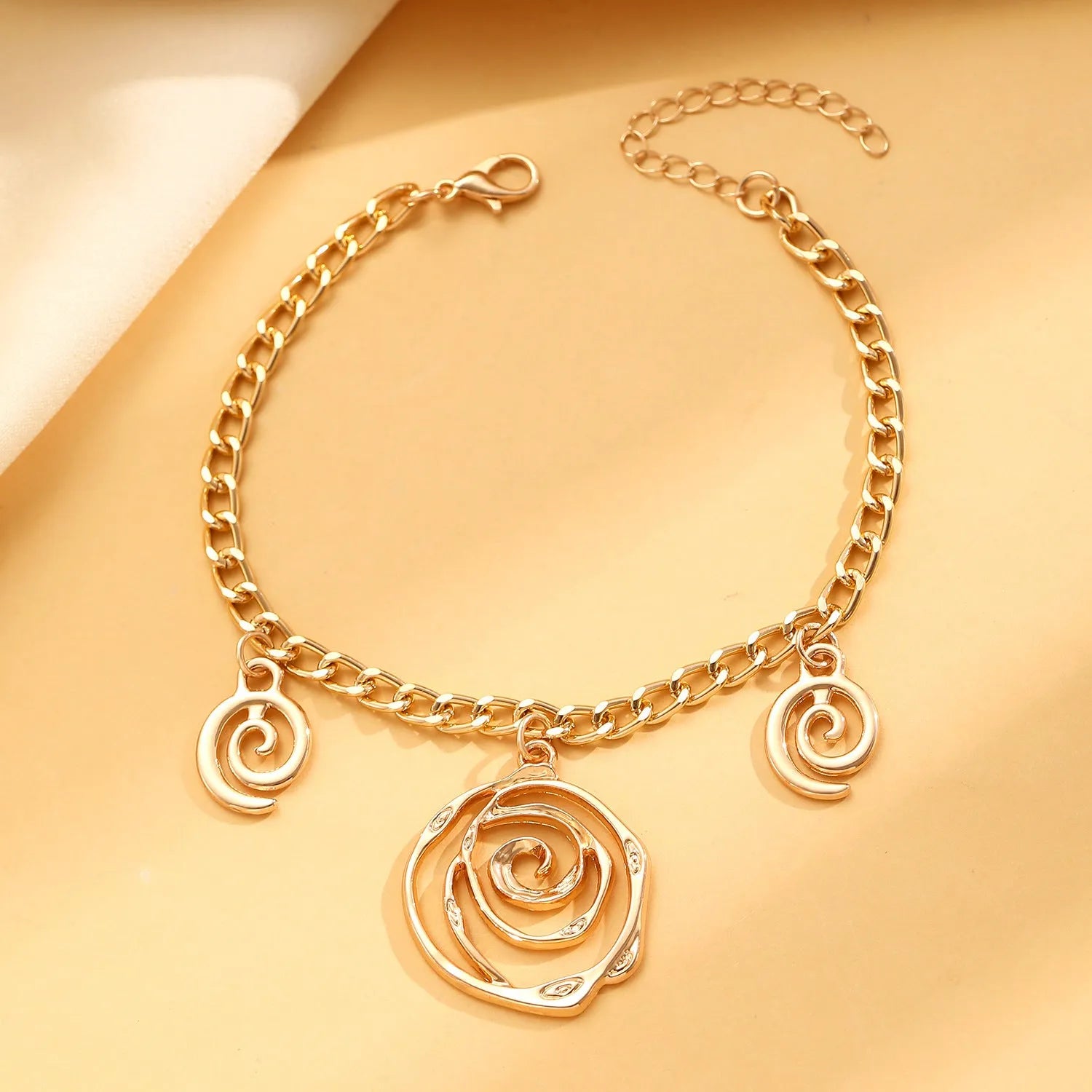 Spiral donut jewellery set showing gold tone necklace, bracelet and earrings with geometric circular design