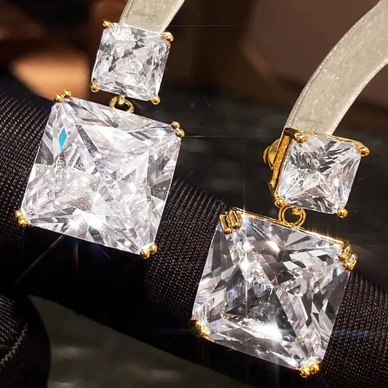 A pair of copper geometric square earrings with a quadrilateral design in a gold colour finish.