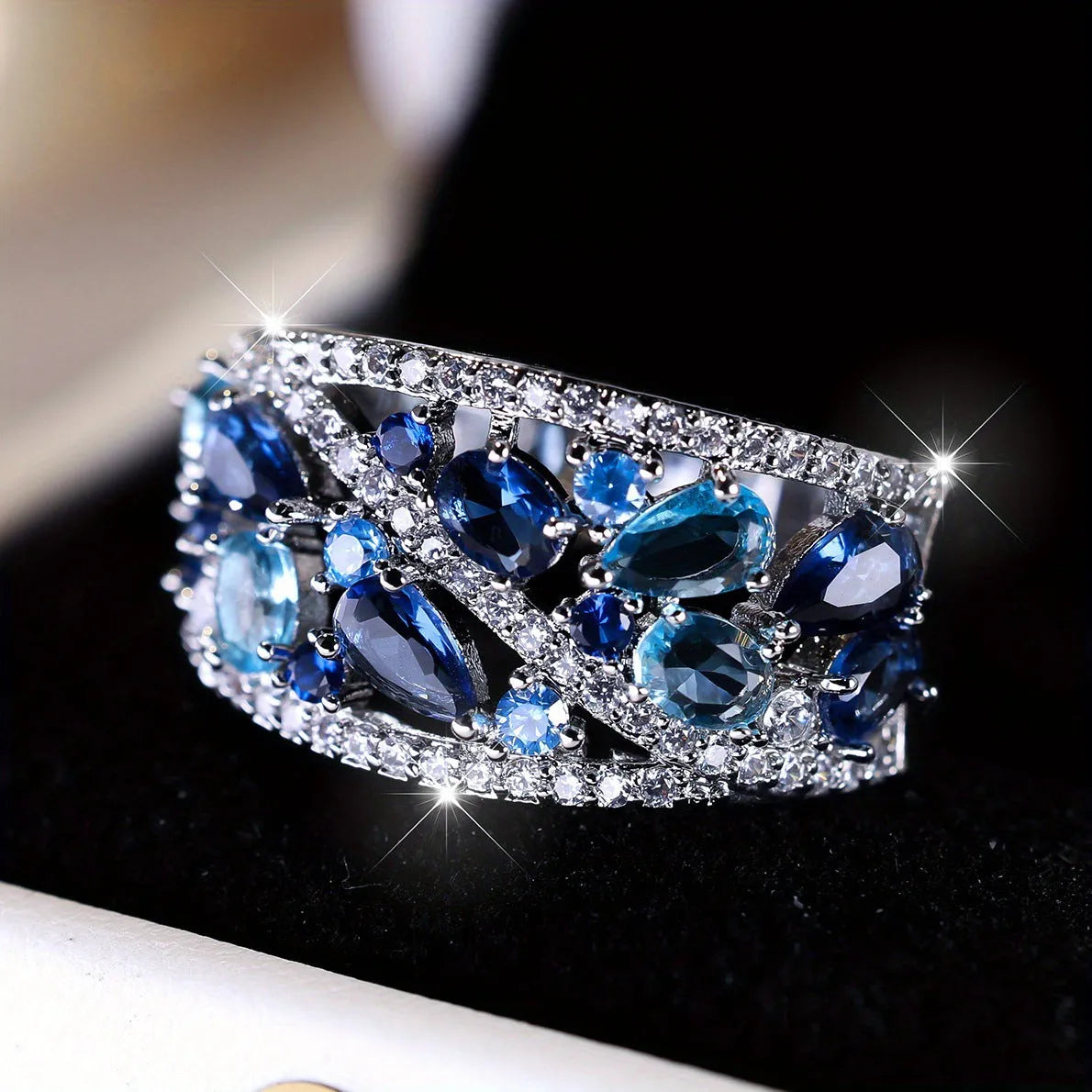 Women's round hollow copper fashion ring with a choice of platinum or gold finish and white or blue stone.
