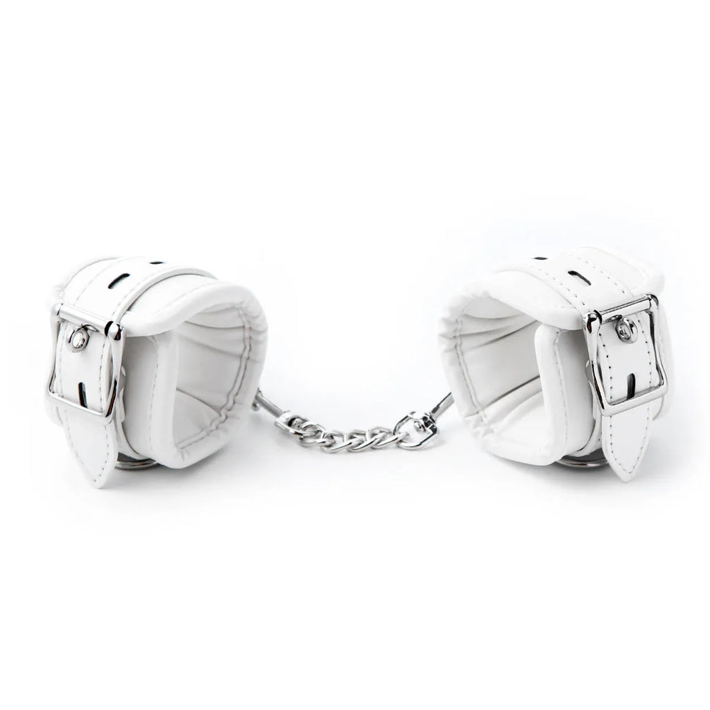 White PU sponge bondage set showing handcuffs, footcuffs, and a neck scarf laid out.