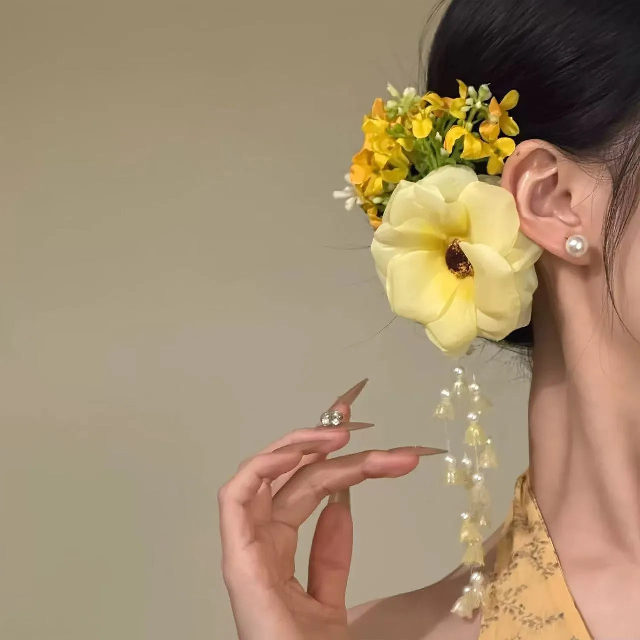 Close-up of a handcrafted hair clip with a colourful flower tassel decoration on a side-clip base.