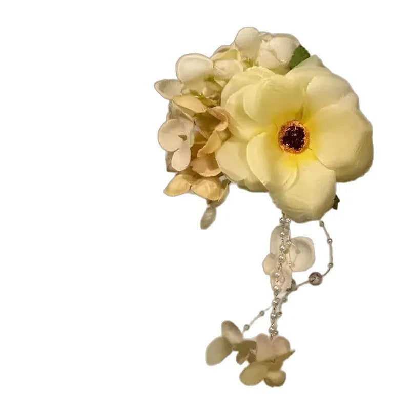 Close-up of a handcrafted hair clip with a colourful flower tassel decoration on a side-clip base.