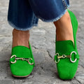 Green women's suede loafers with a metal fastener, flat rubber sole, and round toe.