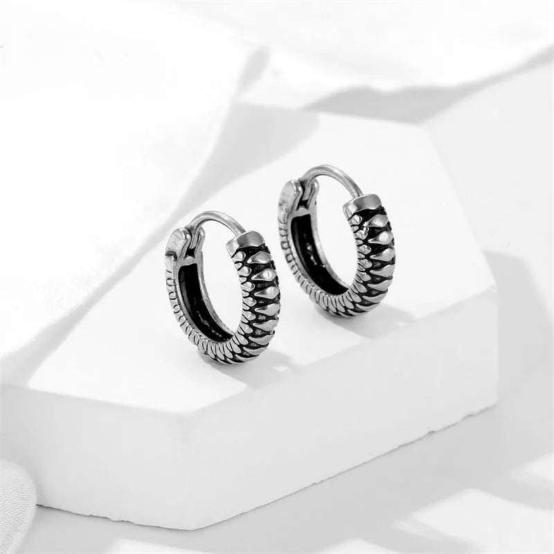 Silver geometric twist earrings with striped pattern and round sports style elements