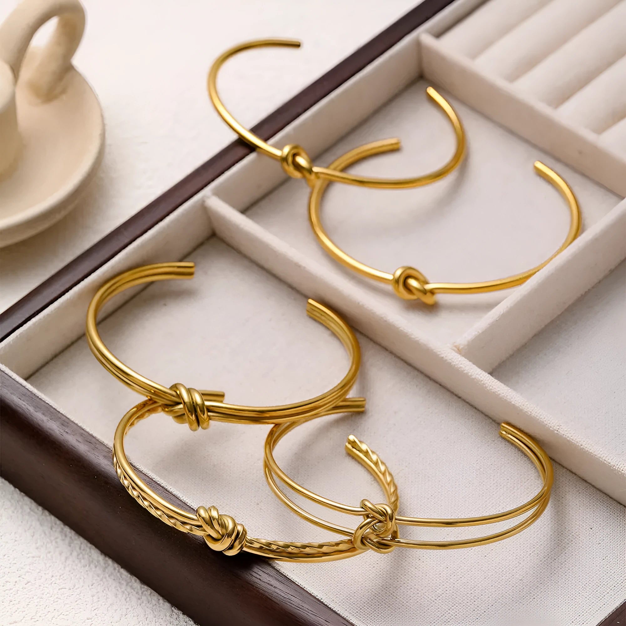 Women's stainless steel bracelet with knotted C-shaped open design in gold plating