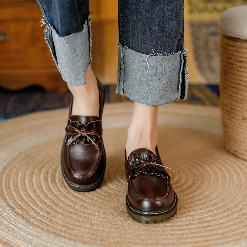 Women's black round-toe leather shoes with a chunky flat heel and lace-up front.