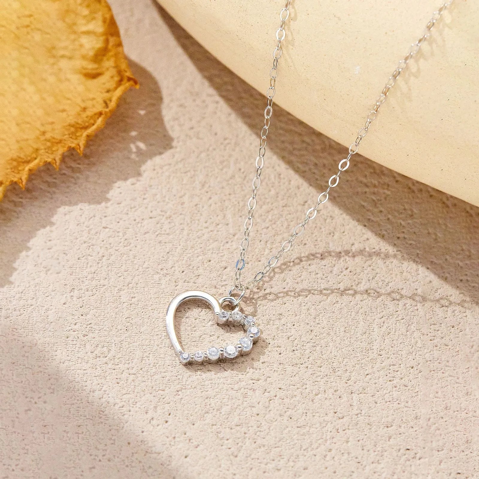 S925 sterling silver hollow heart necklace on a model, showing white gold and 18K gold plated finish options.