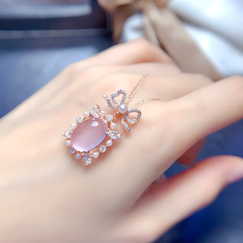 Geometric silver pendant necklace with a pink rose quartz crystal and rose gold plating.