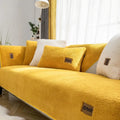 Solid colour lambswool sofa cover on a couch with matching pillow cover.